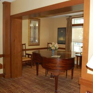 A cozy room featuring a grand piano with wooden decor.