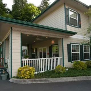 A residential building with a porch and greenery.