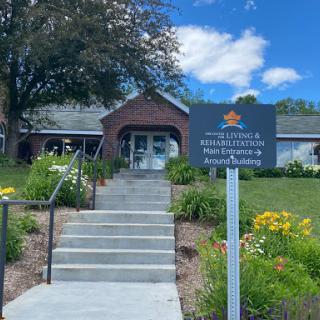 A welcoming entrance to a community resource center with vibrant landscaping and clear signage.