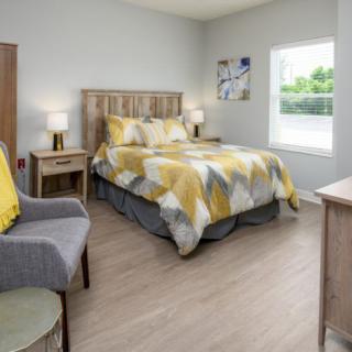 A cozy bedroom with a wooden bed, geometric-patterned bedding, and stylish decor.