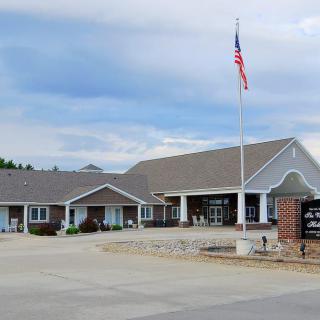 A building with a flagpole and an American flag flying under a cloudy sky.