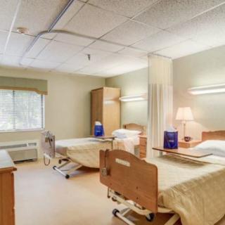 A hospital room with two beds and medical equipment.