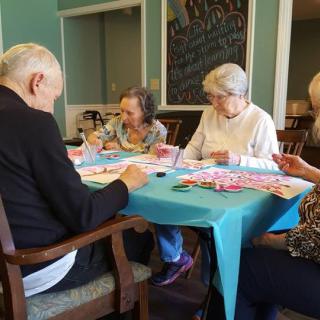 A group of seniors participating in an art activity indoors.