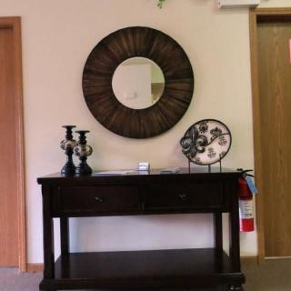A stylish entryway featuring a decorative mirror and a wooden table adorned with candlesticks and a plate.