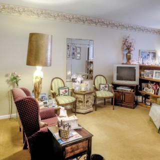 A cozy vintage-style living room with a TV, comfortable seating, and decorative elements.
