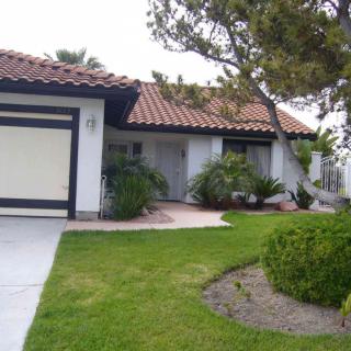 A single-story house with a tiled roof and well-maintained front yard.