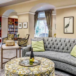 A well-decorated living room featuring a plush sofa, patterned table, and art on the walls.