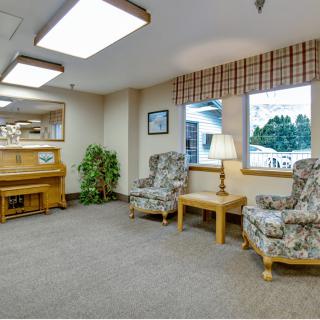 A cozy waiting area with a piano and seating arrangements.