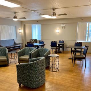 A comfortable lounge area with chairs and tables arranged on a wooden floor.