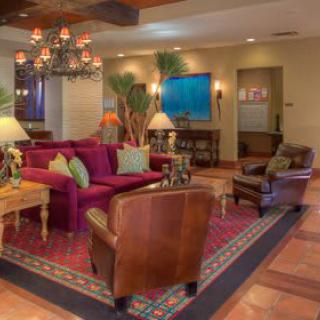 A cozy and elegantly decorated living room with sofas, armchairs, and a chandelier.