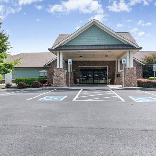 A commercial building with a covered entrance and handicap parking spaces in front.