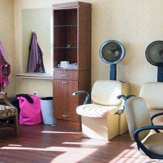 A cozy salon interior with hair dryers and seating, ready for clients.