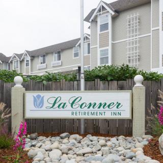 Entrance sign of La Conner Retirement Inn with landscaped surroundings.