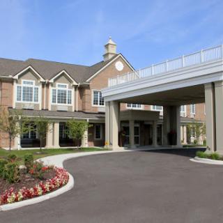 A view of a modern residential building featuring an inviting entrance and landscaped surroundings.