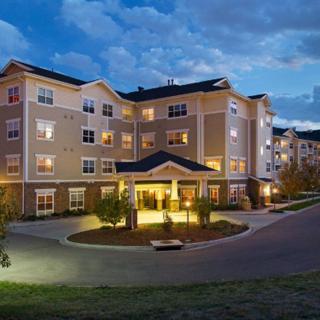 A well-lit residential building at night with landscaped surroundings.