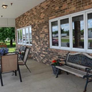 A cozy outdoor patio with seating and a brick wall.