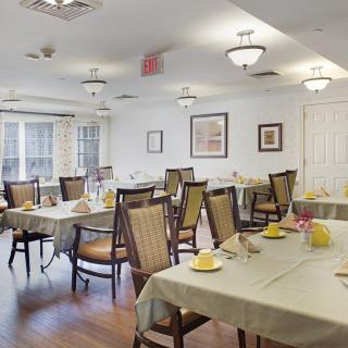 A well-lit dining room with neatly arranged tables and chairs, featuring a cozy atmosphere.