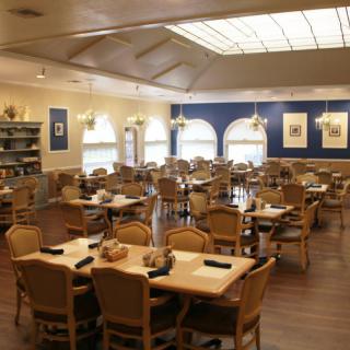 A well-lit restaurant dining area with neatly arranged tables and chairs.