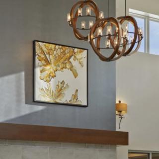 A modern living room featuring a stylish chandelier and abstract wall art.