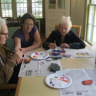 A group of people engaged in a painting activity at a table.