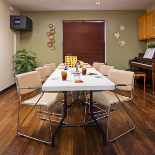 A well-organized room with a long table and chairs, featuring decor and wooden flooring.