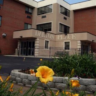A welcoming entrance to a residential building, adorned with vibrant flowers.