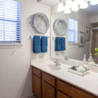 A neatly arranged bathroom with decorative elements and blue towels.