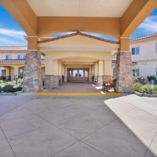 A welcoming entrance with a covered walkway and landscaped surroundings.