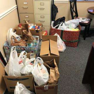 A collection of grocery items and donations neatly arranged in an office space.