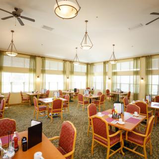 A well-lit dining area with neatly arranged tables and chairs.