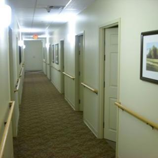 A well-lit corridor with multiple doors and handrails along the walls.