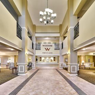 Spacious hotel lobby with elegant chandelier and reception desk.