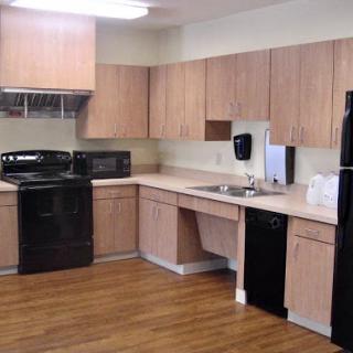 A modern kitchen featuring black appliances and wooden cabinets.