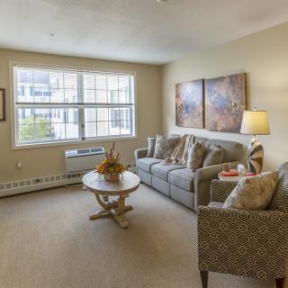 A cozy living room with a comfortable sofa, coffee table, and large window.
