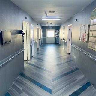 A clean and well-lit hospital corridor with doors on either side.