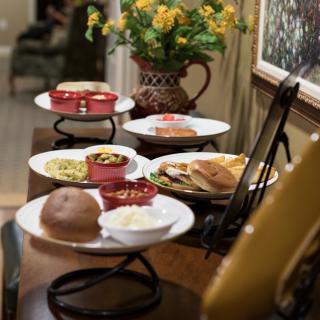 A dining table set with various plates of food, including bread and side dishes, ready for a meal.