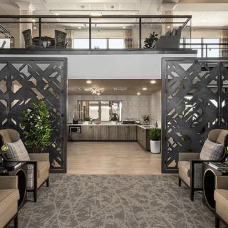 A modern lobby with decorative panels, comfortable seating, and greenery.