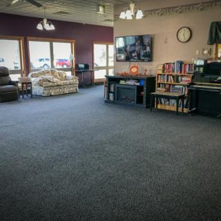 A spacious living room with a television, bookshelves, and comfortable seating.