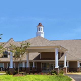A welcoming residential building with well-maintained landscaping under a clear blue sky.