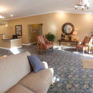 A spacious and elegantly decorated lobby with seating, plants, and a reception desk.
