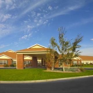 A modern building with a red brick exterior under a clear blue sky.