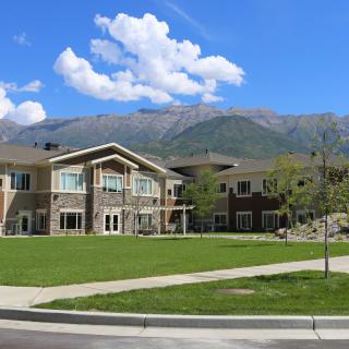 A scenic view of a building with mountains and a blue sky in the background.