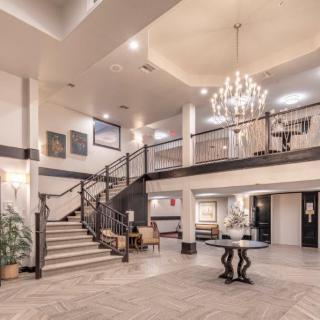 A spacious hotel lobby with a grand chandelier and elegant staircase.