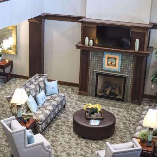 A cozy and well-decorated living room with sofas, chairs, a fireplace, and a coffee table.