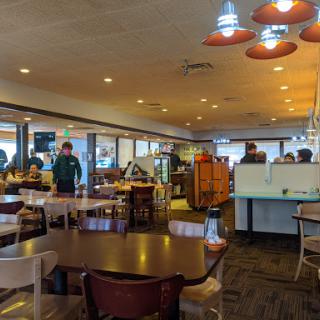 A cozy dining area in a restaurant, featuring tables and staff attending to customers.