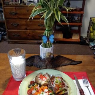 A beautifully arranged meal on a dining table featuring colorful vegetables and a refreshing glass of water.