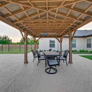A spacious patio with a wooden pergola and outdoor dining set.