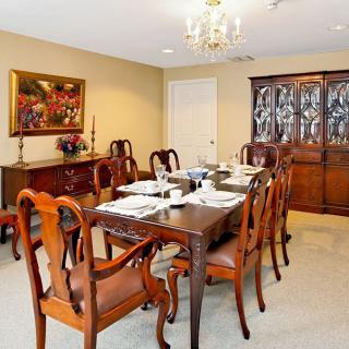 A classic dining room with elegant wooden furniture and a chandelier.