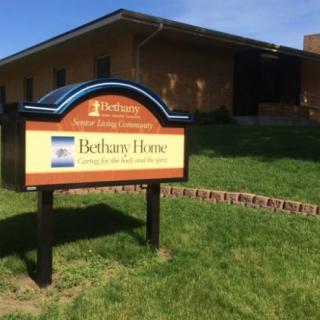 Sign for Bethany Home outside a building with grass in the foreground.