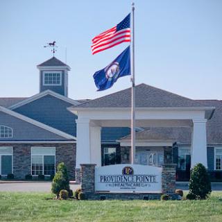 The entrance of a building featuring the United States and Virginia flags.
